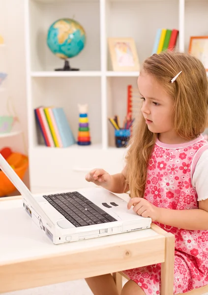 Küçük kız bir dizüstü bilgisayarda işlemek öğrenme — Stok fotoğraf
