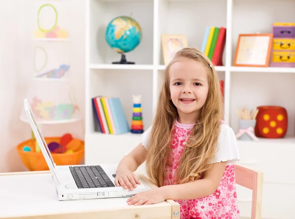 Menina em seu quarto trabalhando no computador portátil — Fotografia de Stock