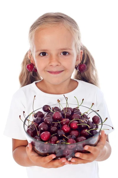 Little girl with cherry earrings holding a bowl of fresh fruits — Stock Photo, Image