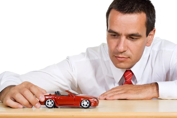 赤のおもちゃの車を持ったビジネスマン — ストック写真
