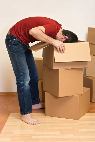 Homem desembalando de caixas de papelão em uma nova casa — Fotografia de Stock