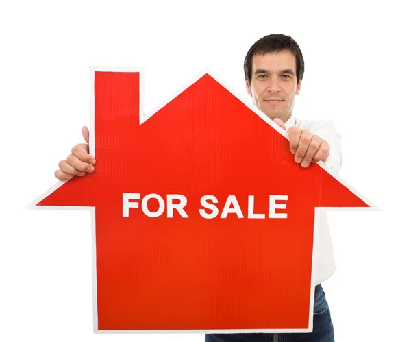 Confident salesman with house for sale sign — Stock Photo, Image