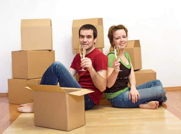 Couple toasting in their new home sitting on the floor — Stock Photo, Image