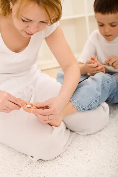 Mulher cortando pequenos meninos dedo do pé — Fotografia de Stock