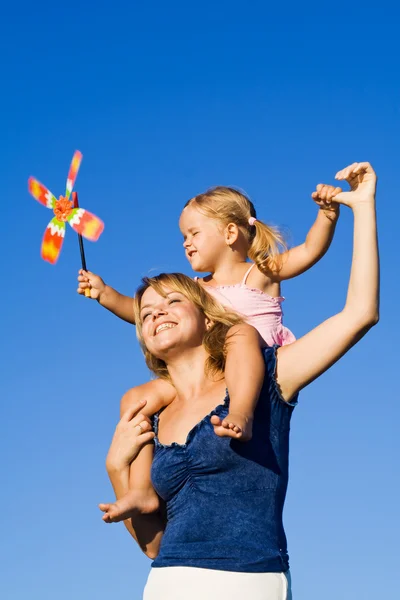 小女孩和一个风车玩具户外的女人 — 图库照片