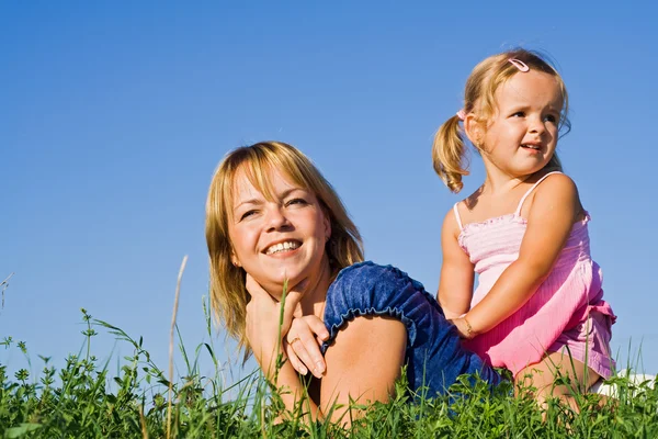 Женщина и маленькая девочка в траве — стоковое фото
