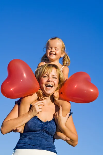 Vrouw met klein meisje en ballonnen — Stockfoto