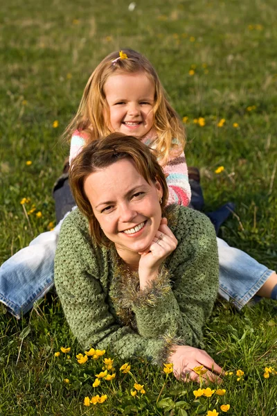 Kvinna och liten flicka på våren ängen — Stockfoto