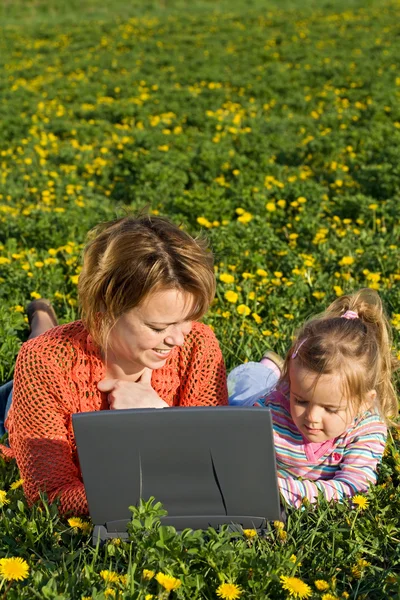 Женщина и девочка на весеннем цветочном поле — стоковое фото