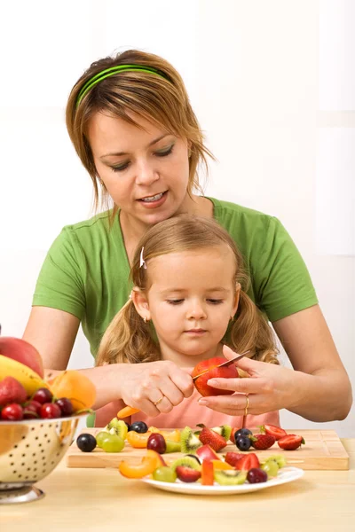 Donna e bambina affettare frutta — Foto Stock