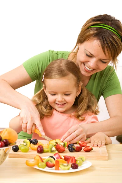 Mujer y niña preparando ensalada de frutas —  Fotos de Stock