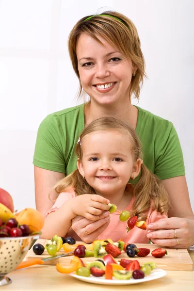 Frau und kleines Mädchen machen Fruchtspieße — Stockfoto