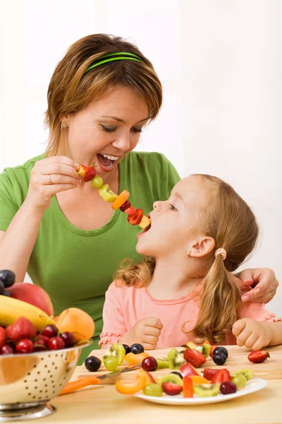 Eating a healthy snack - fruit slices on stick — Stock Photo, Image