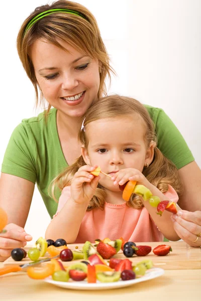 Φρούτα σε ραβδί - γυναίκα και κοριτσάκι προετοιμασία υγιεινό σνακ — Φωτογραφία Αρχείου