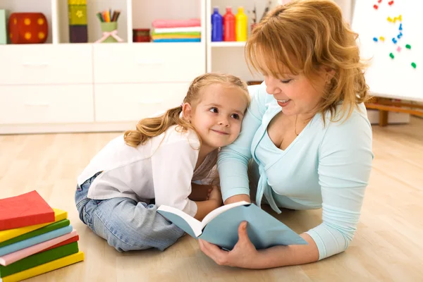 Frau liest ihrem kleinen Mädchen vor — Stockfoto