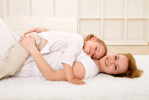 Woman and little girl relaxing on the floor — Stock Photo, Image