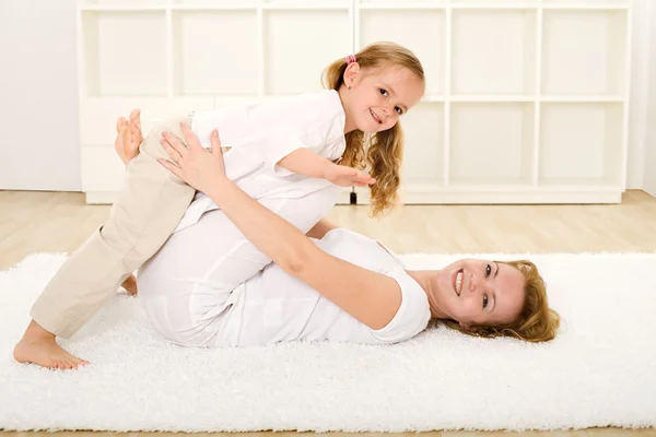 Little girl and woman playing indoors on the floor — Stock Photo, Image