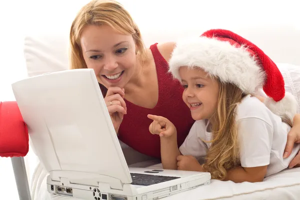 Mujer y niña jugando en un ordenador portátil en Navidad — Foto de Stock