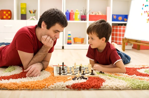 Muž učí chlapce pravidla šachů — Stock fotografie