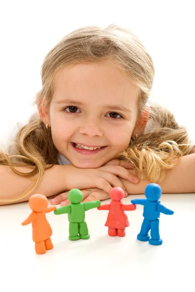 Маленькая девочка улыбается со своей глиняной семьей Лицензионные Стоковые Фото