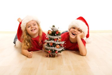 Happy kids on the floor at christmas time clipart