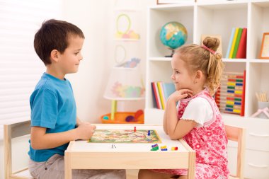 Kids playing board game in their room clipart