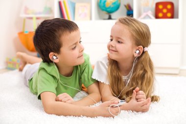 Kids sharing earphones listening to music