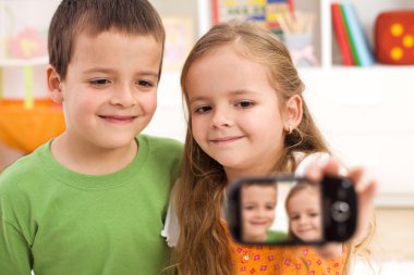 Say cheese - kids taking a photo of themselves clipart