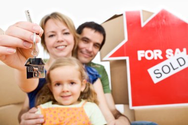 Happy new homeowners - family moving concept clipart