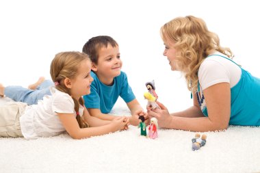 Woman telling a story to her kids on the floor clipart