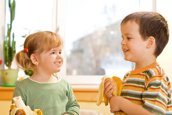 Två barn äta bananer — Stockfoto