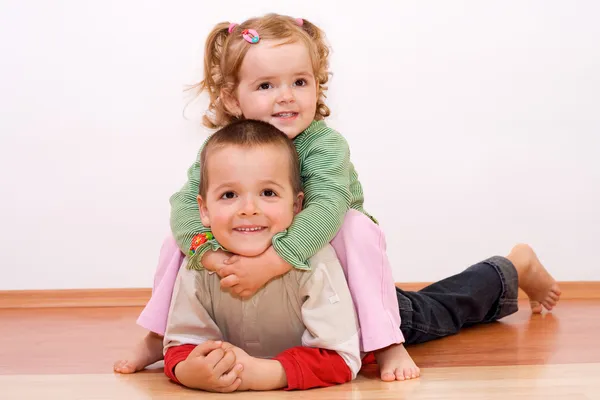 Bambini felici che giocano sul pavimento — Foto Stock