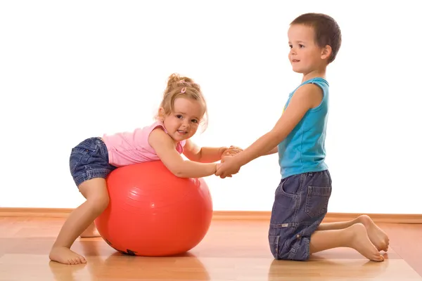 Маленький мальчик учит свою сестру гимнастике — стоковое фото