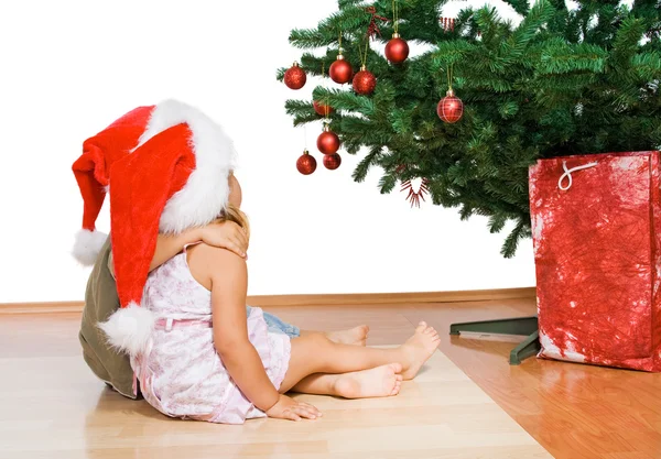 Barnen tittar på julen träd kramas — Stockfoto