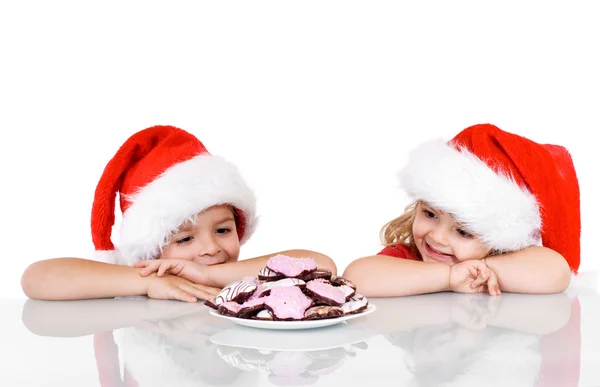 Ευτυχής παιδιά κοντά σε ένα πιάτο με τα μπισκότα Χριστουγέννων — Φωτογραφία Αρχείου