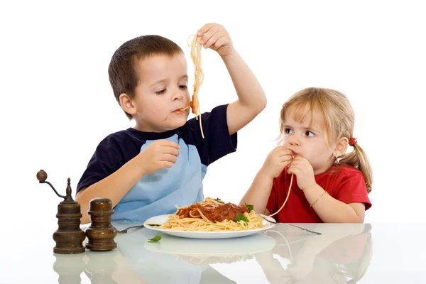 Iki çocuk kendi elleriyle makarna yemek — Stok fotoğraf