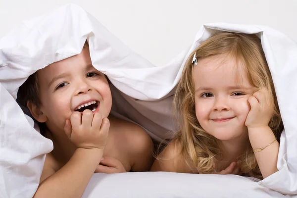 Niños divirtiéndose en la cama — Foto de Stock