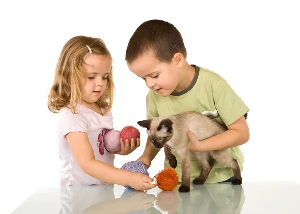 Crianças brincando com seu gato — Fotografia de Stock