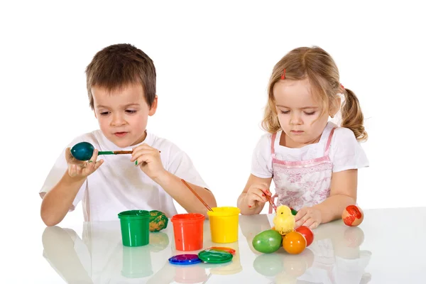 Хлопчик і дівчинка малюють великодні яйця — стокове фото