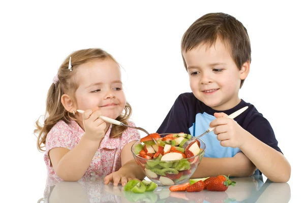 Šťastné děti jíst ovocný salát — Stock fotografie