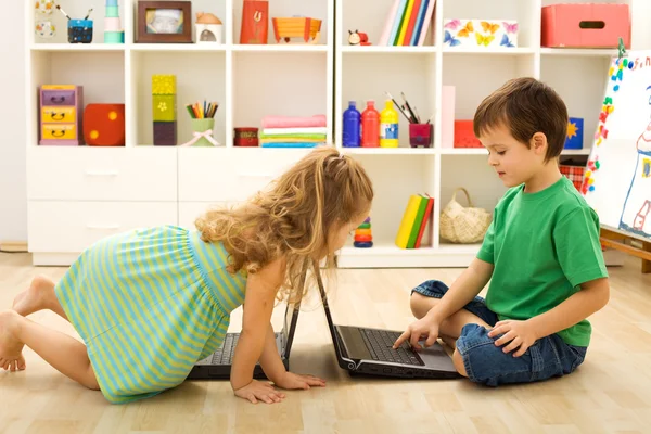 Crianças ensinando umas às outras usando os computadores — Fotografia de Stock