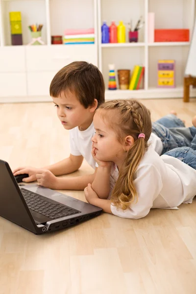 Niños ocupados y concentrados trabajando en un portátil — Foto de Stock