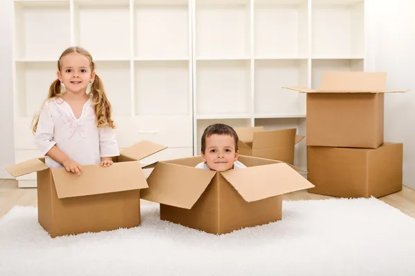 Kids in their new home with boxes — Stock Photo, Image