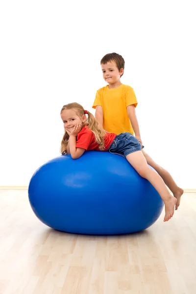 Crianças brincando com uma grande bola de exercício — Fotografia de Stock