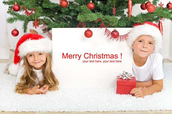 Τα παιδιά για τον κάτω από το χριστουγεννιάτικο δέντρο — Φωτογραφία Αρχείου