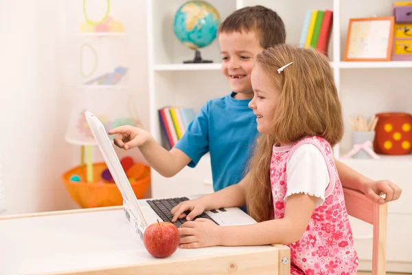 Evde dizüstü bilgisayar üzerinde oynayan çocuklar — Stok fotoğraf