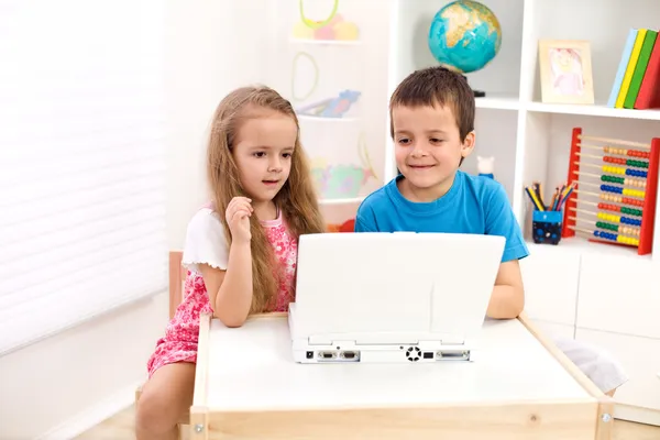 Duas crianças olhando para o computador portátil — Fotografia de Stock
