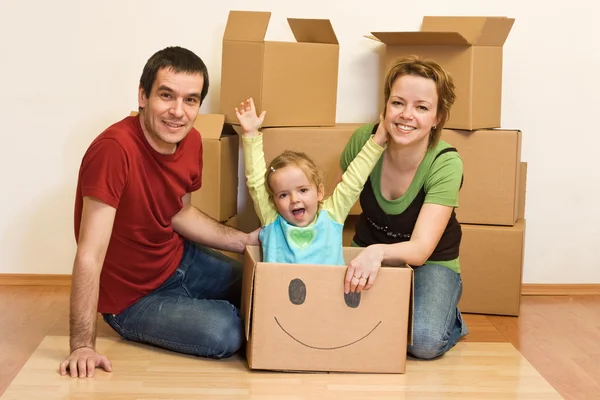 Família feliz em sua nova casa sentada no chão — Fotografia de Stock