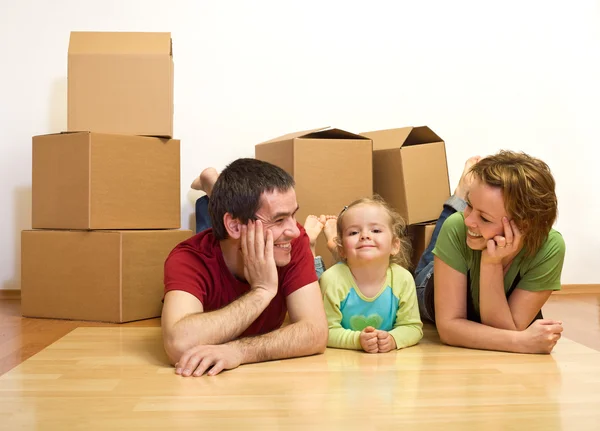 Happy couple with a kid in their new home — Stock Photo, Image