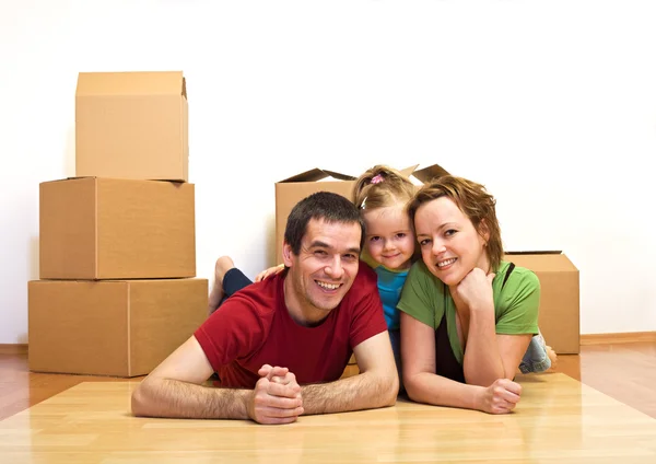 Happy family laying on the floor in their new home — Stock Photo, Image